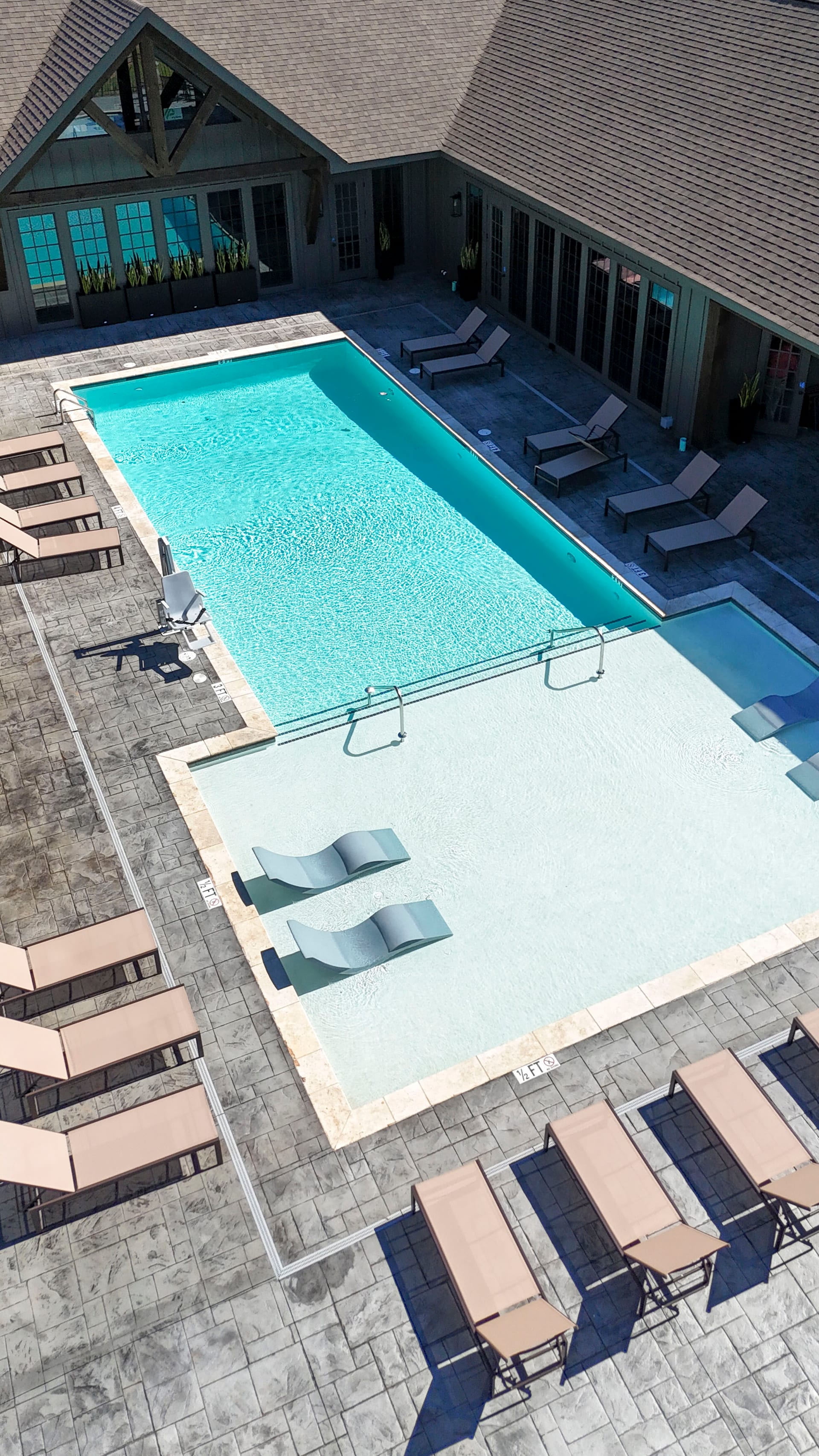 Sun-drenched wading area and loungers frame a perfect afternoon from the air.