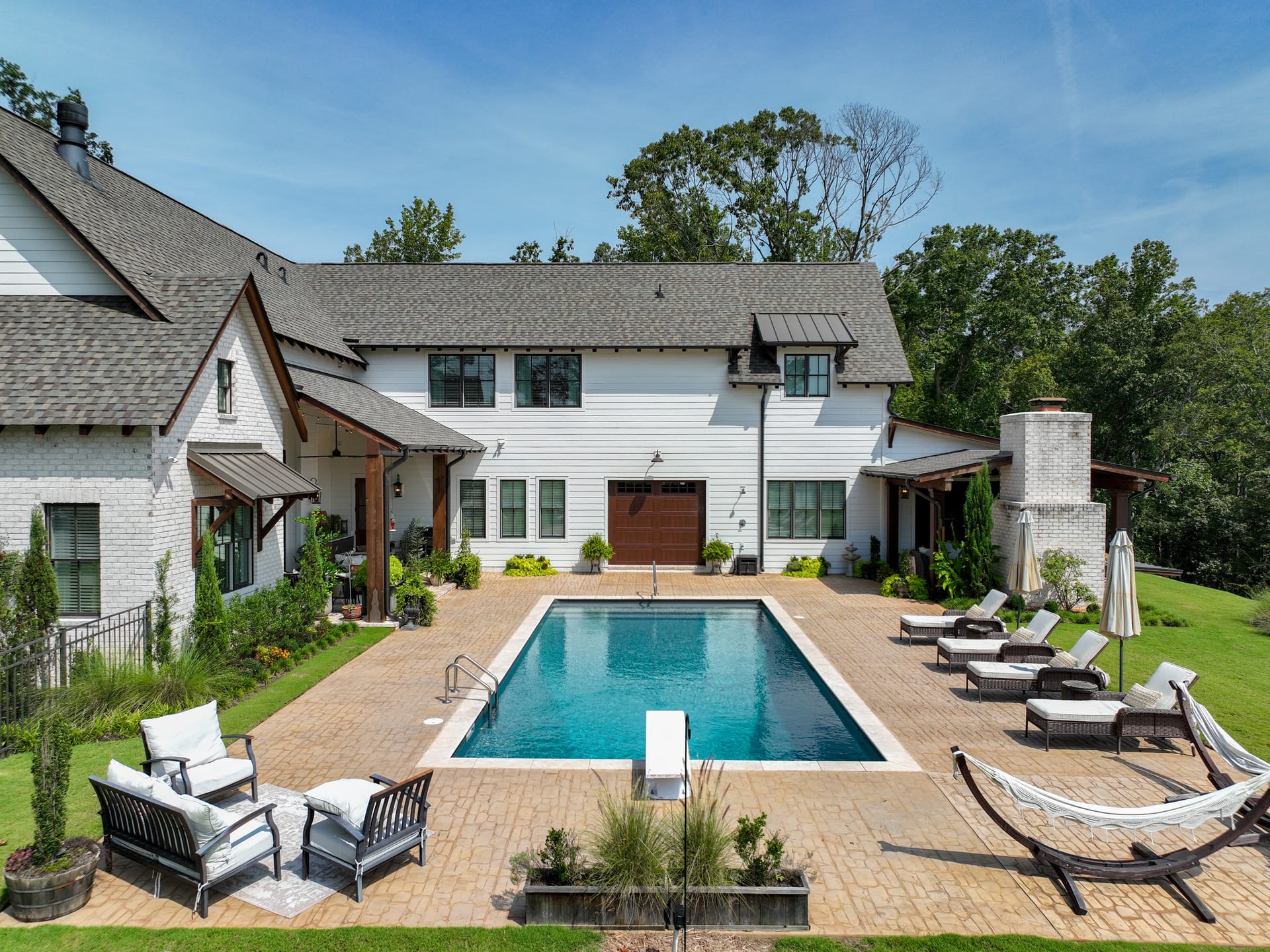 Paver deck and loungers stretch across the rear elevation at golden hour.