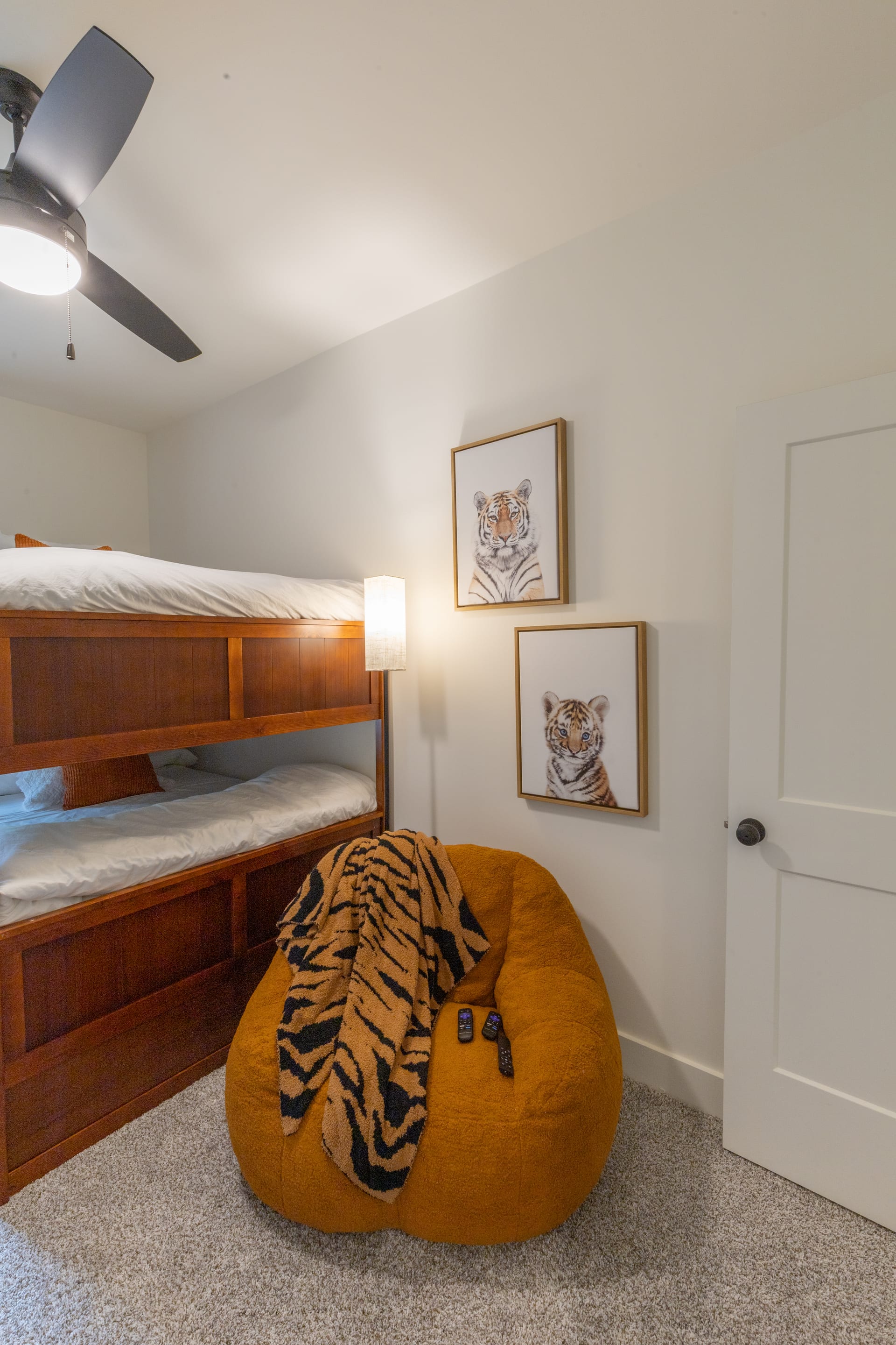 Bold tiger art and cherry bunks create a spirited youth retreat.