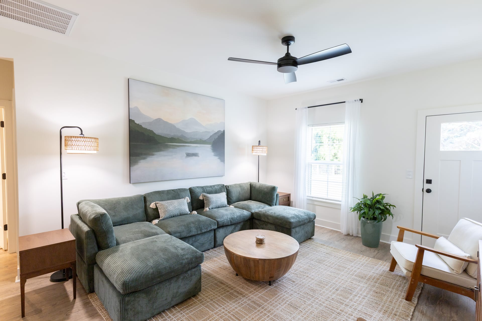 Deep green sectional and a tranquil lake painting set a restful mood.