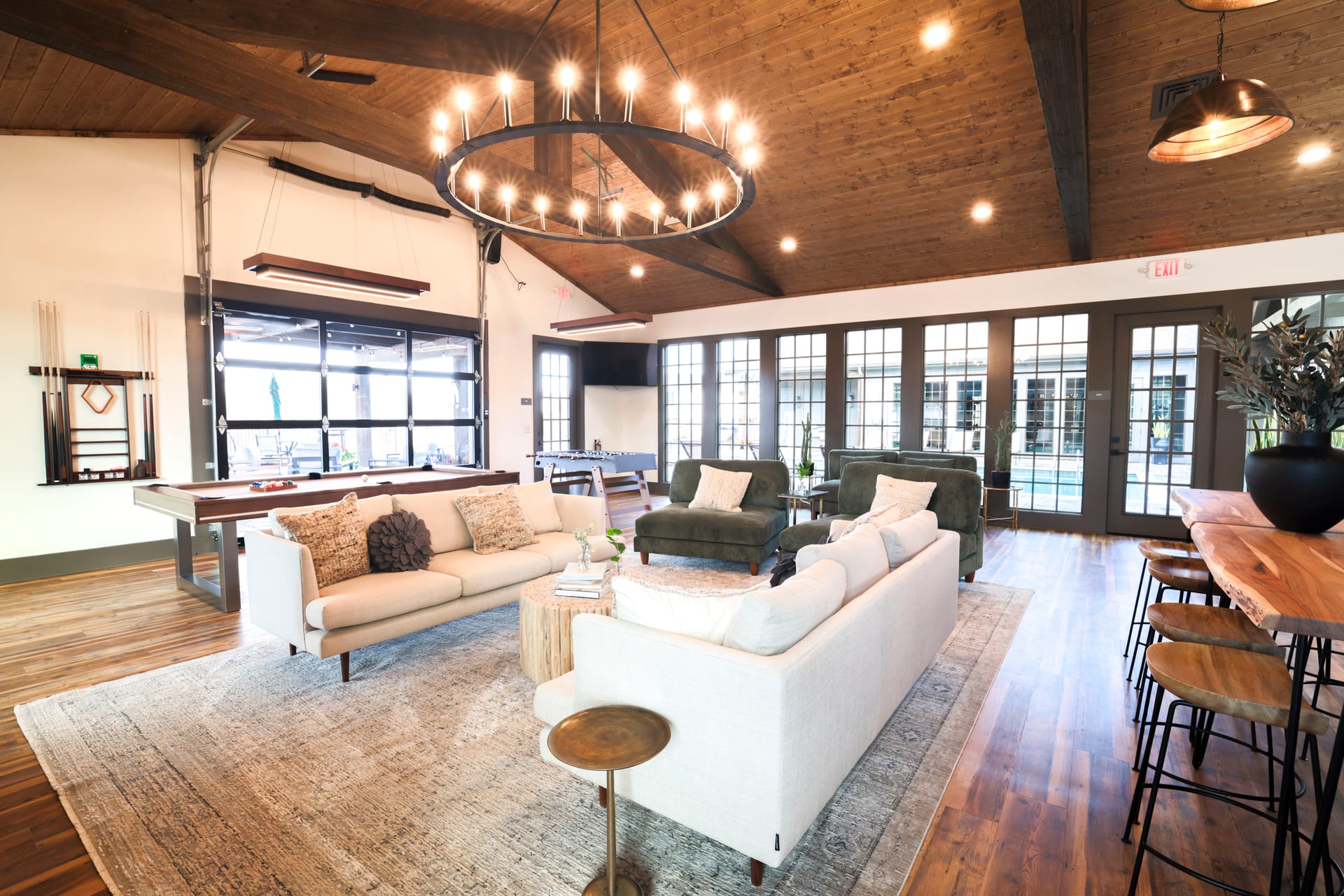 Iron chandelier and cream sofas glow between elegant French doors.