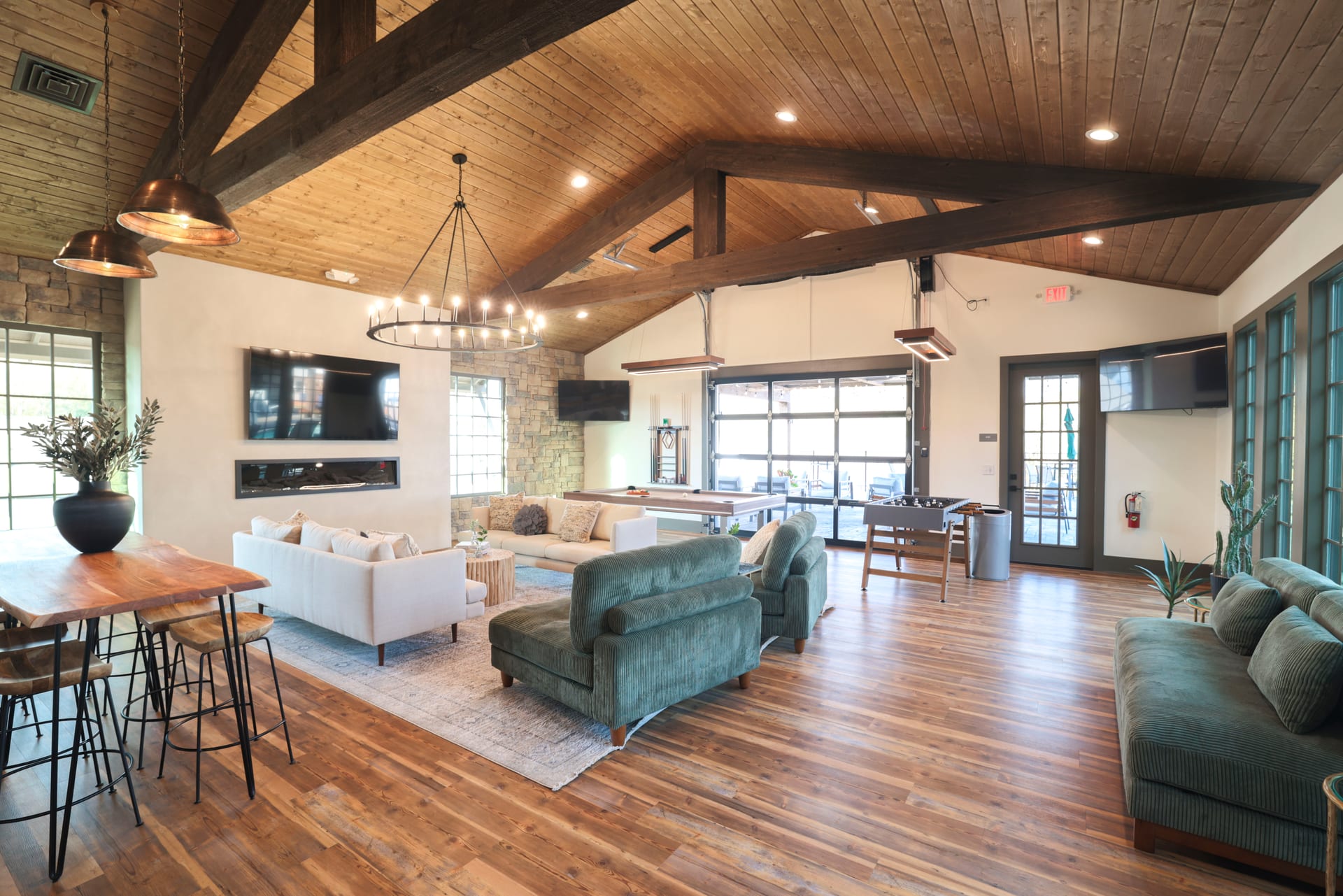 Vaulted ceilings soar above green sofas and a stunning live-edge bar.
