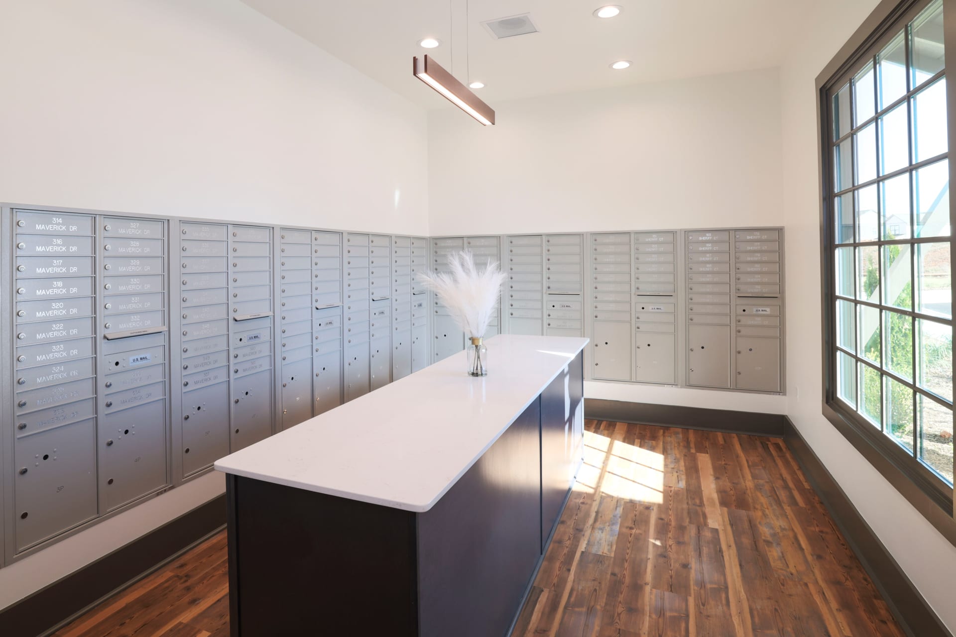 Silver mail cubbies and pampas grass lend quiet elegance to the mailroom.