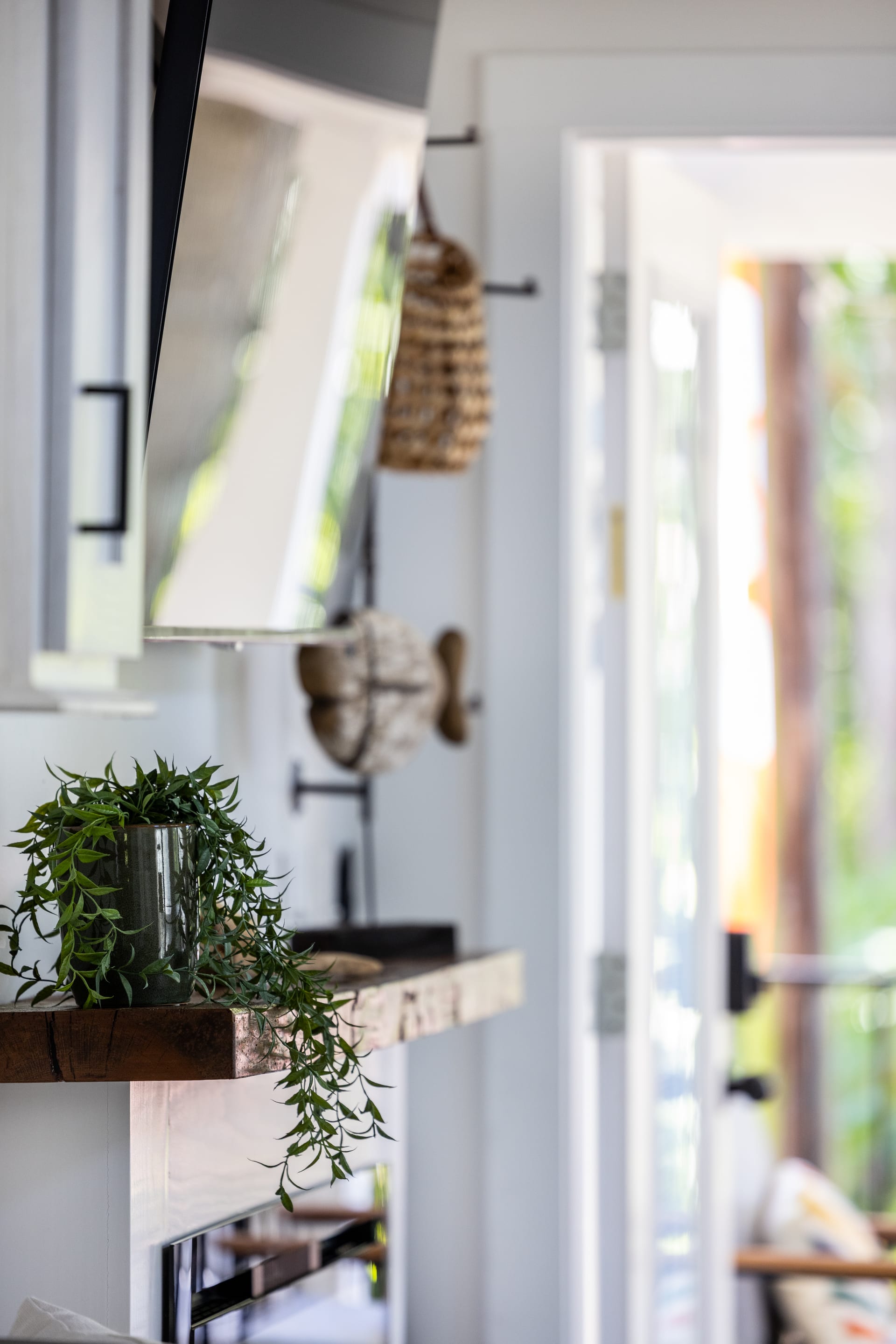 Trailing greenery and woven baskets soften the stone fireplace surround.