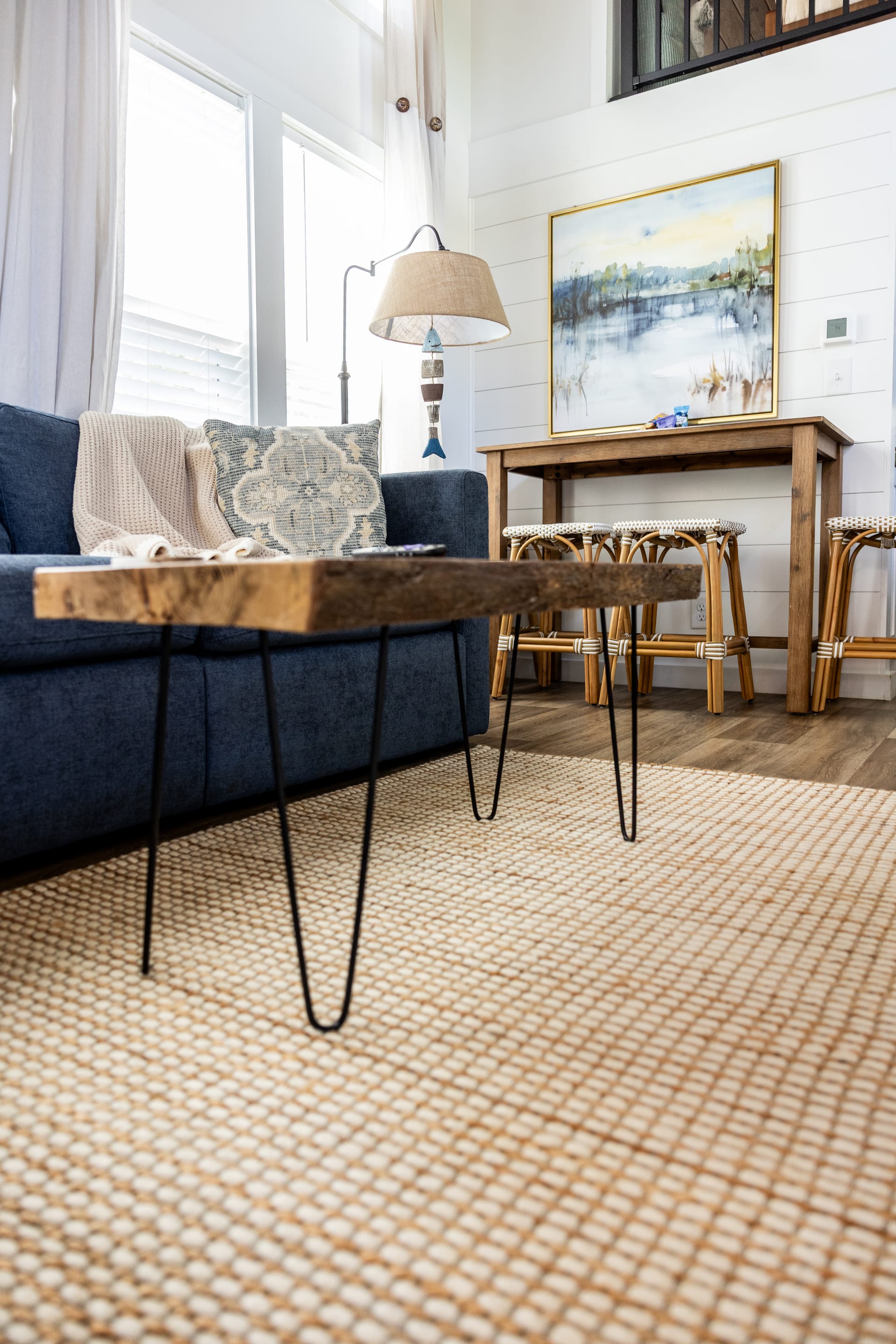 Live-edge coffee table meets navy linen on a grounding jute rug.