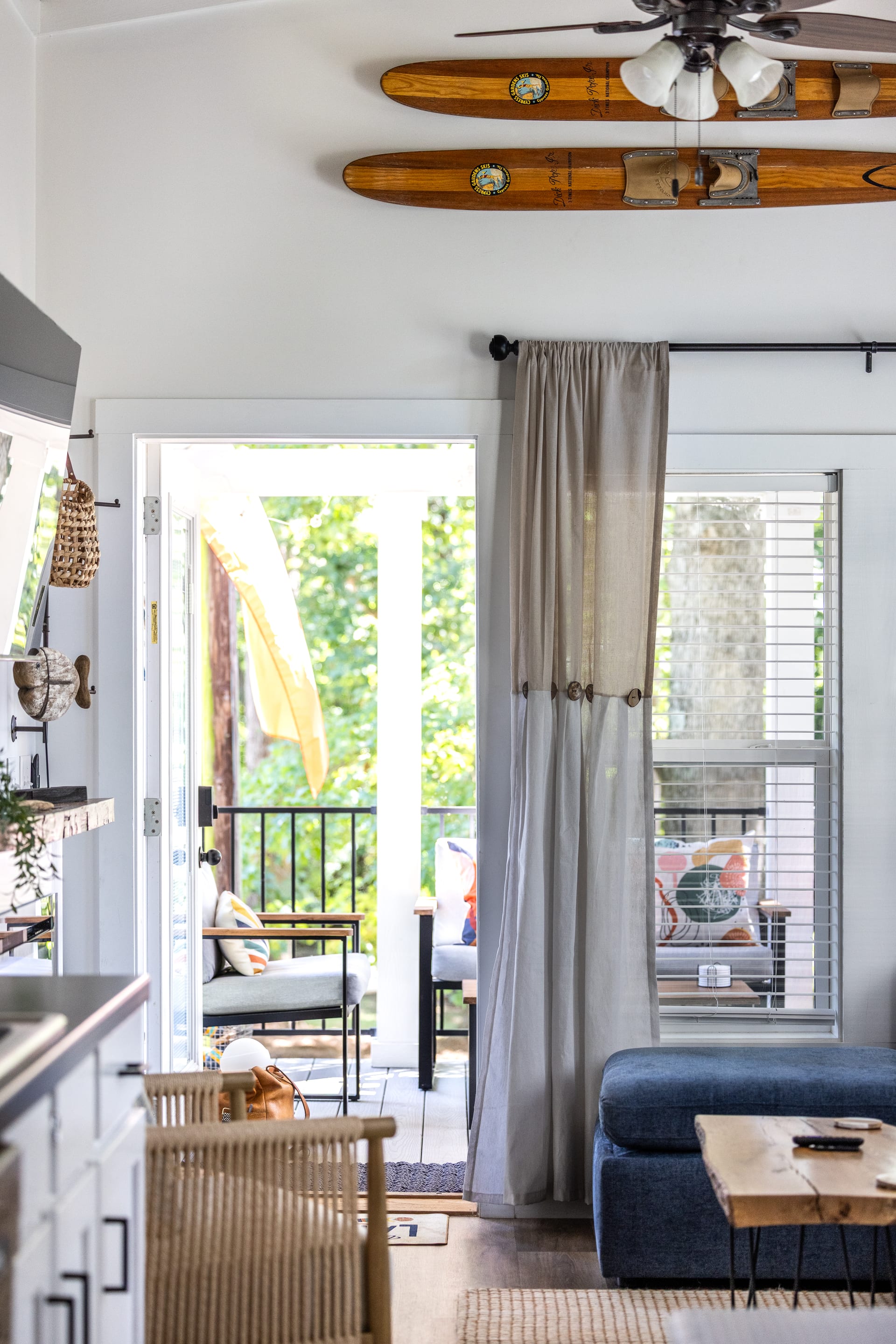 French doors open to the porch — vintage water skis nod to the lake.