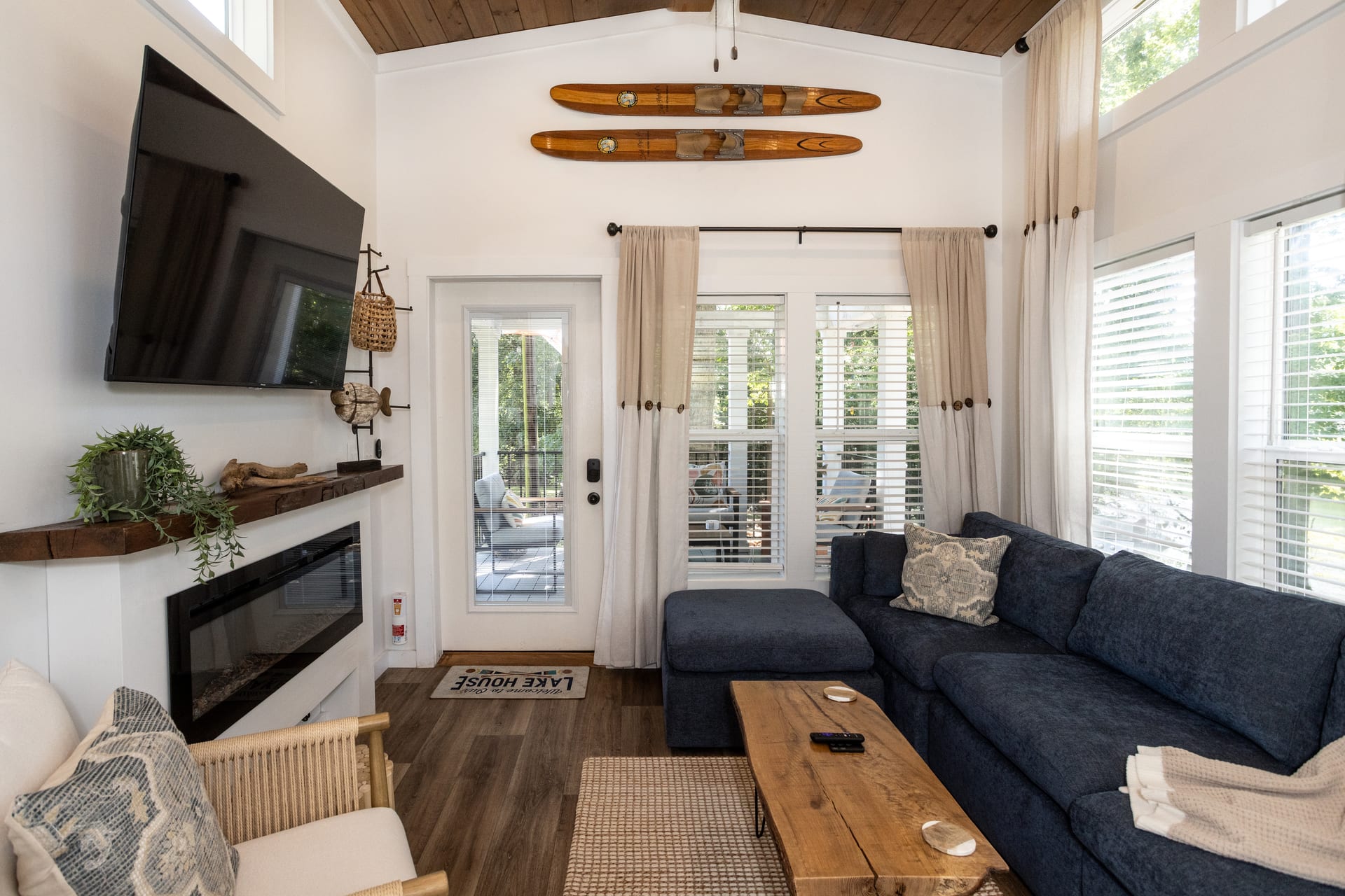 Vaulted wood ceiling soars above the TV wall and stone fireplace.