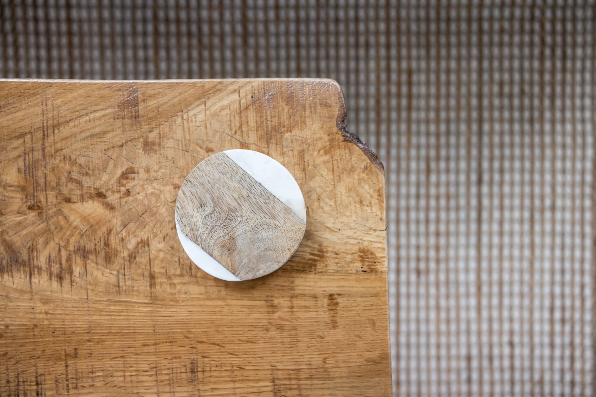 Marble and wood coasters rest on the live-edge table — detail as design.