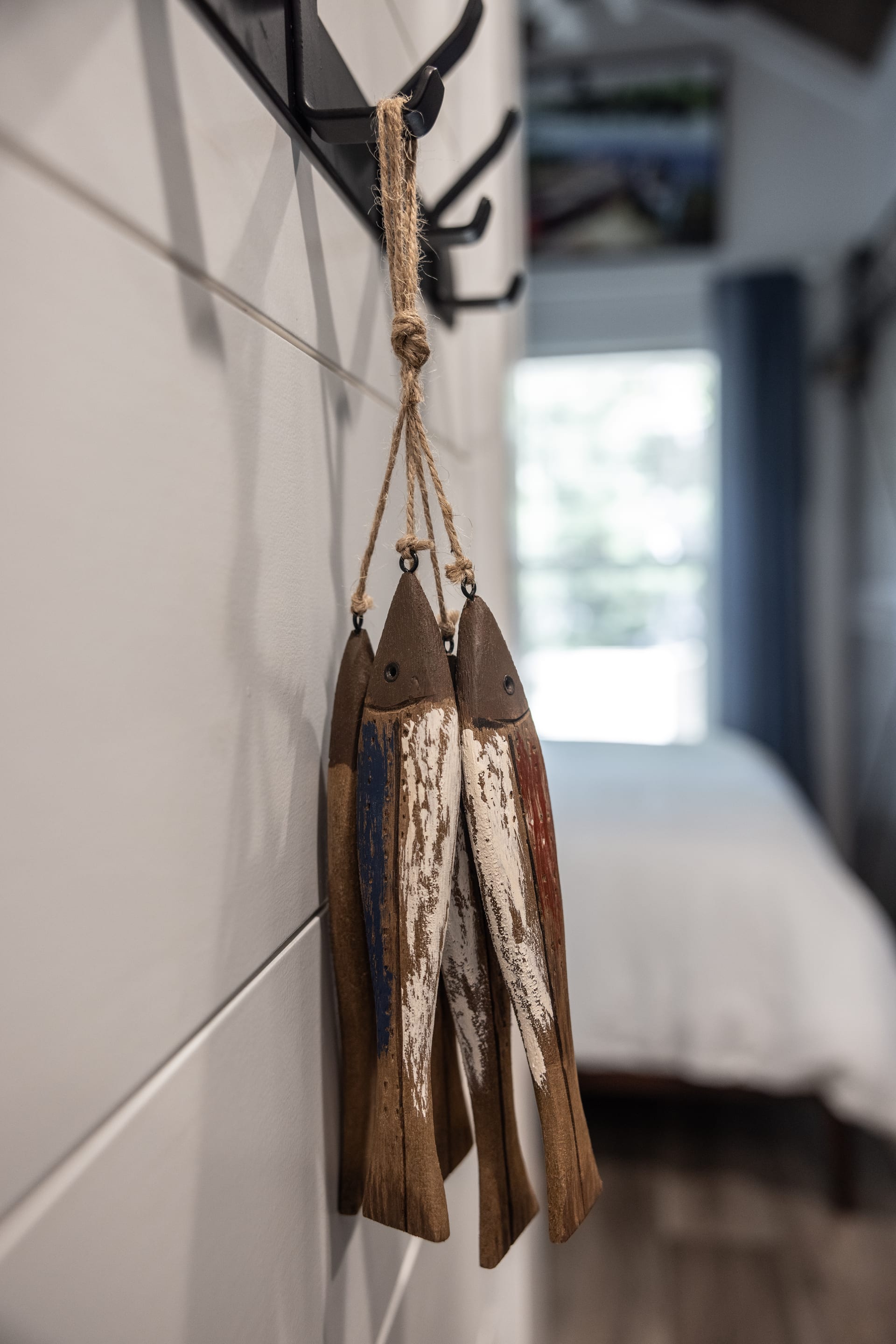 Painted driftwood fish double as wall hooks — whimsy meets function.