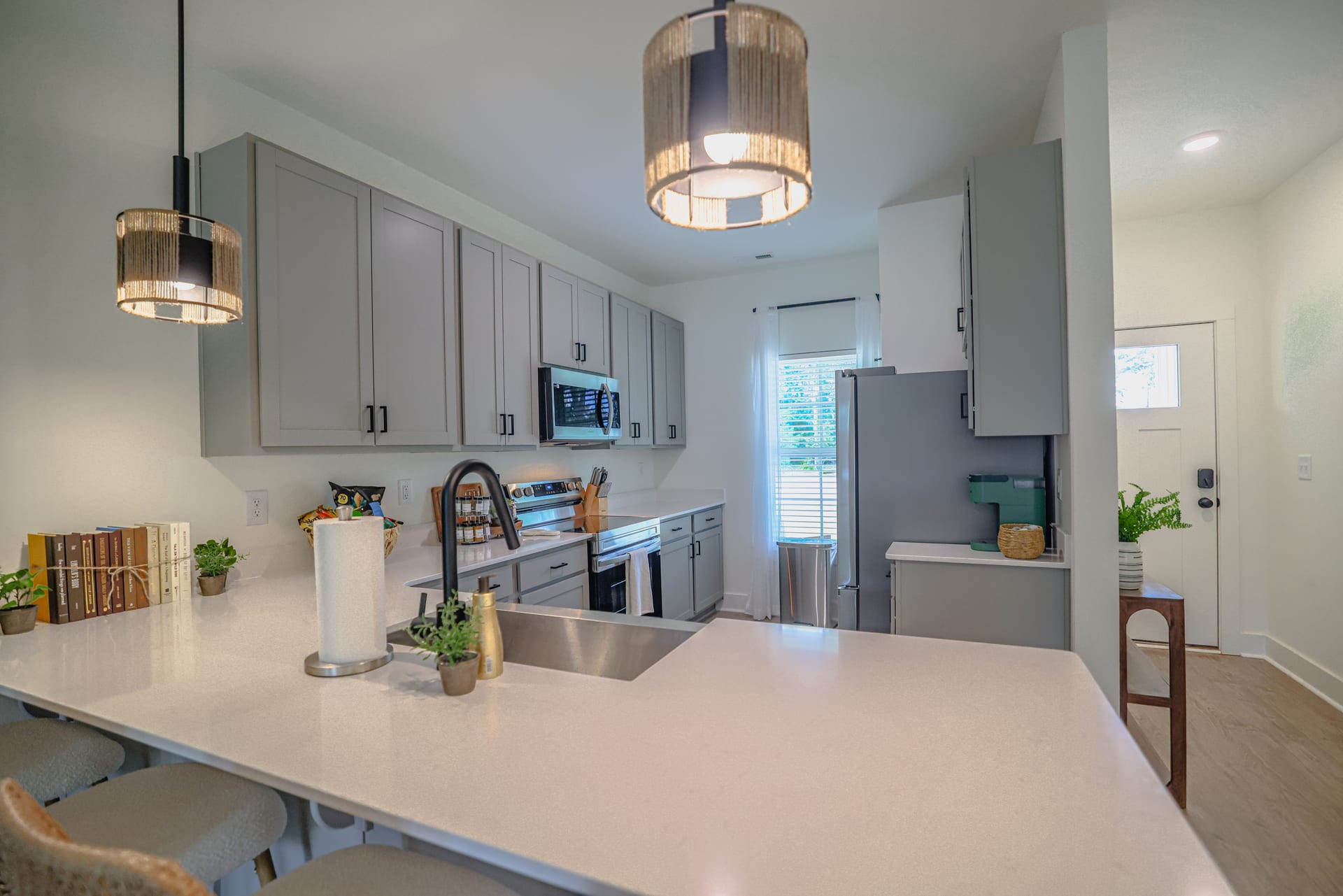 Grey shaker island beneath pendant lights — the heart of the kitchen.