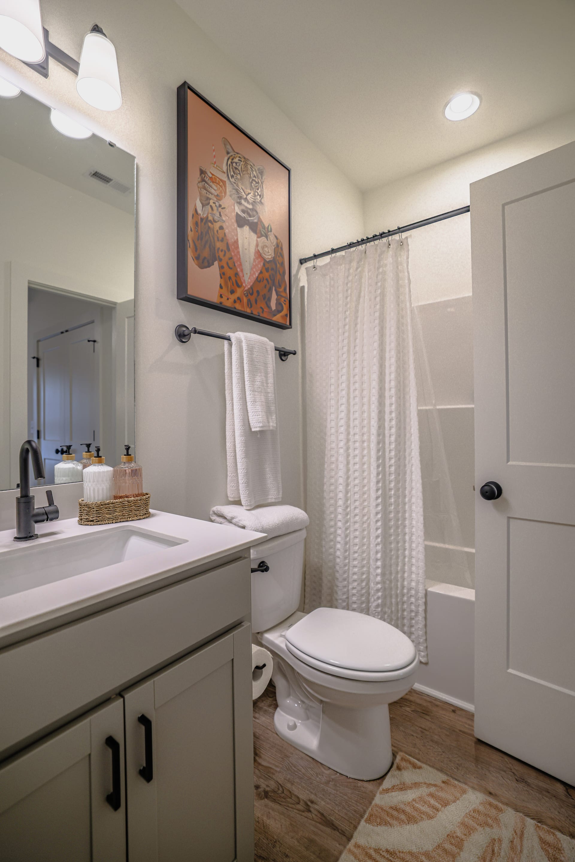 White vanity and playful giraffe art add surprise to a guest bath.