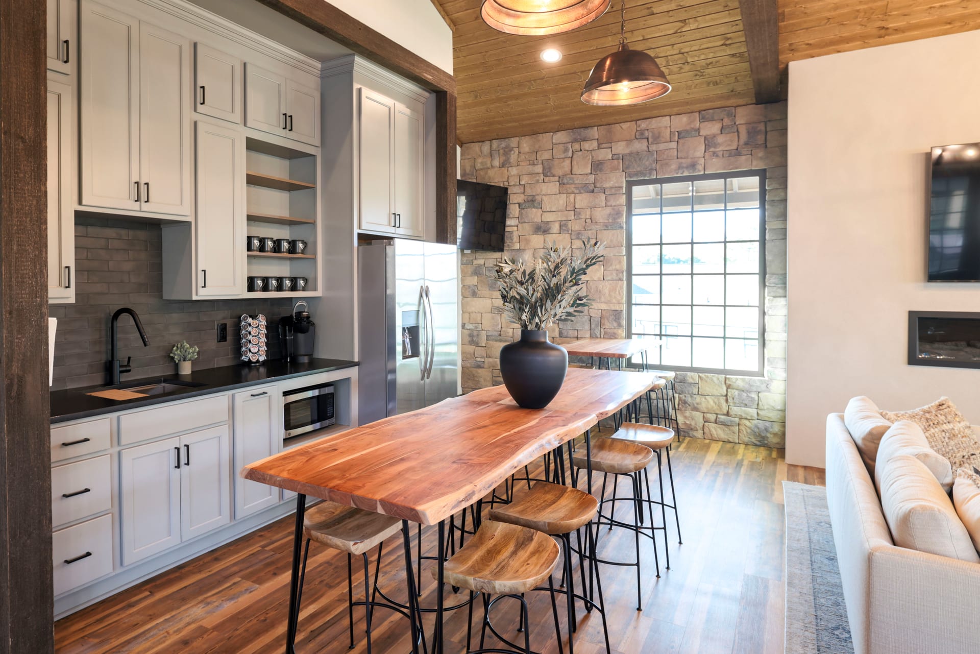 Live-edge counter and stone wall transform the kitchen bar into a statement.