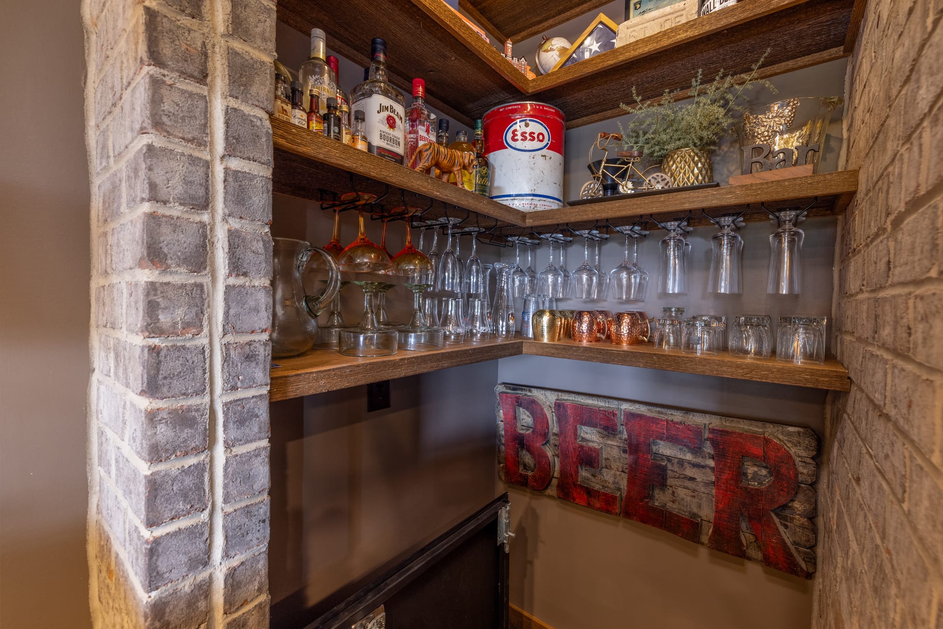 Brick-framed shelves hold curated glassware in the Newton bar nook.