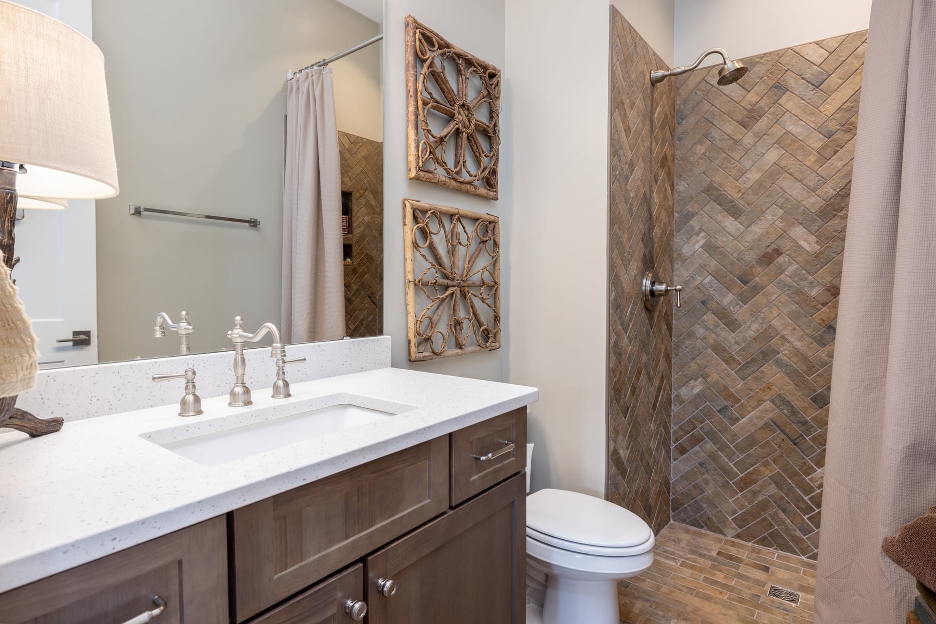 Herringbone tile shower and walnut vanity elevate the guest bath.