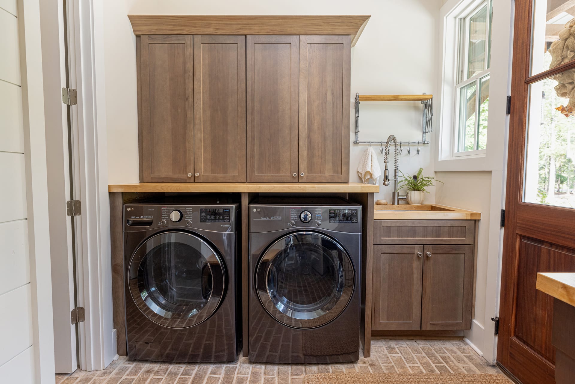 Walnut cabinetry and a deep utility sink make laundry day feel intentional.