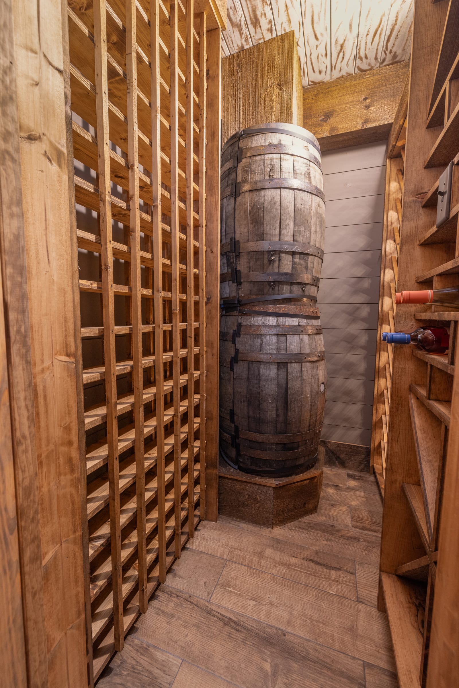 Wooden racks and barrels line the cellar with rustic warmth.