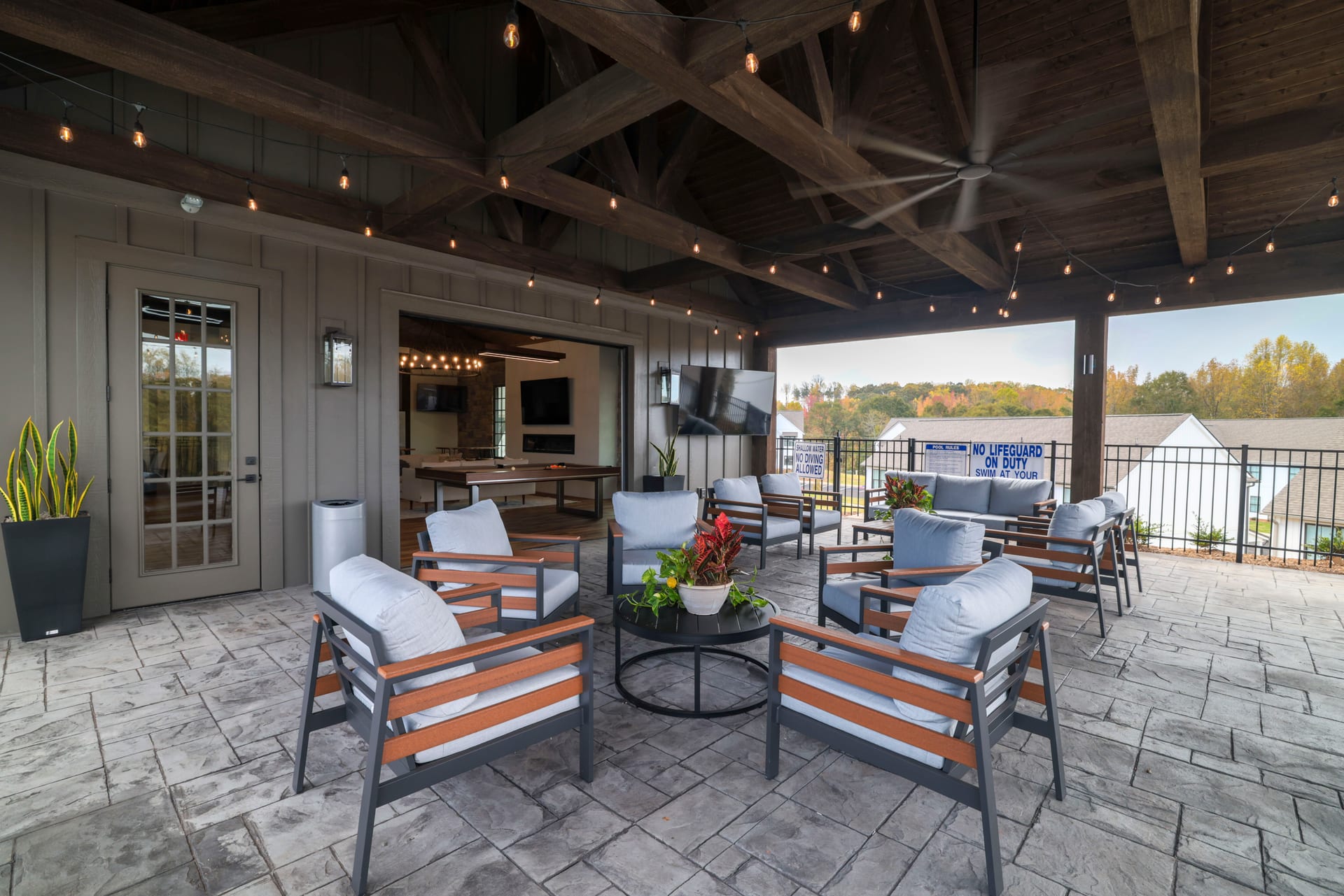 Circular seating and billiards entry blur indoor and outdoor living.