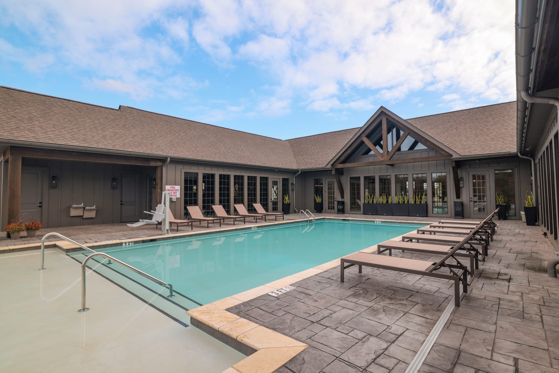 Timber gable and stone patio frame the courtyard pool at the clubhouse.