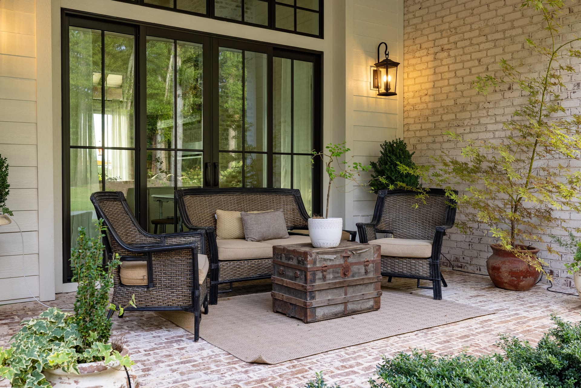 Brick patio, iron lantern, and black French doors — an evening waiting to happen.