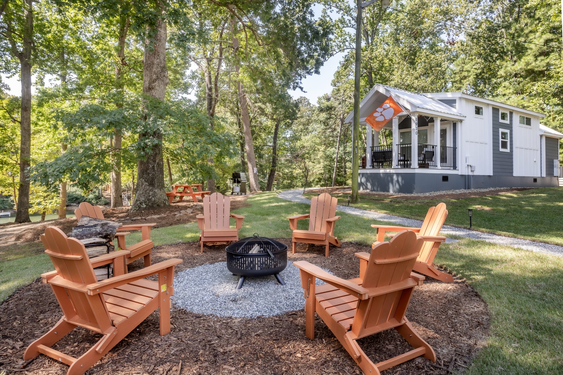 Cedar Adirondack chairs circle the fire pit under open sky.