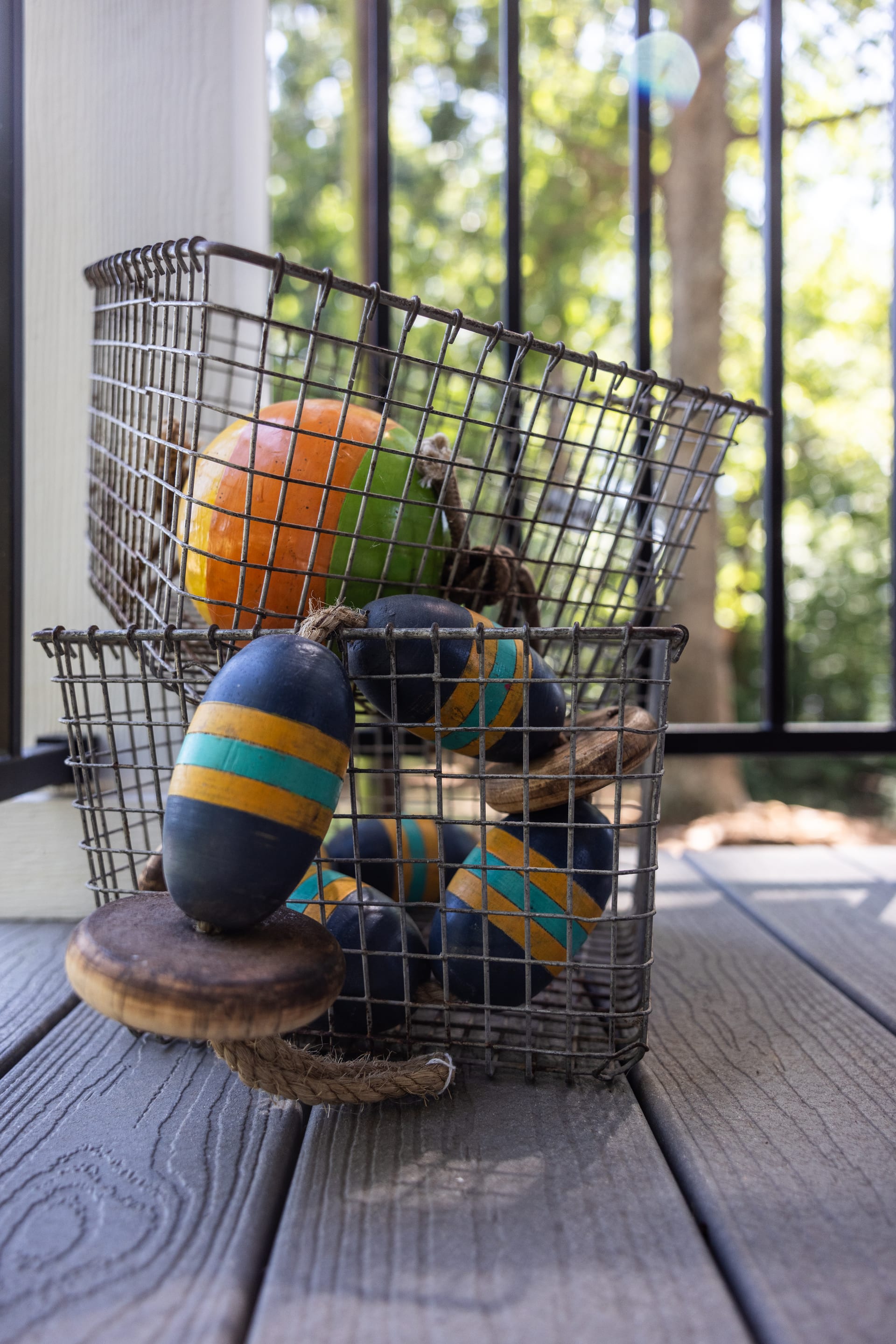 Painted buoys and wire baskets bring lakeside charm to the porch table.